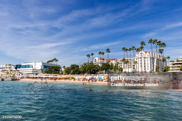 boulevard de la croisette and beach with tourists on a sunny summer day, côte d'azur, france - cannes stock pictures, royalty-free photos & images