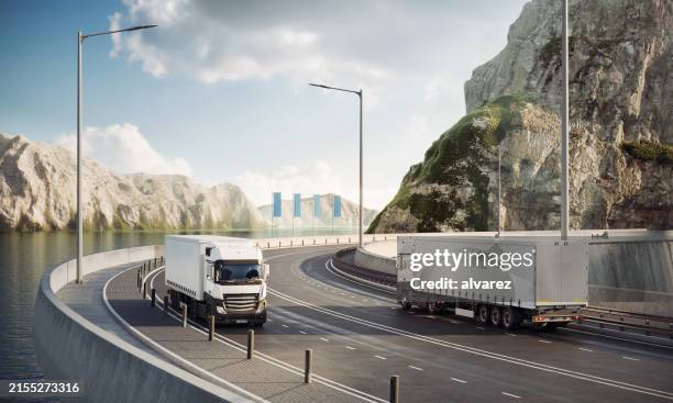 camions de transport générés numériquement sur une route côtière montagneuse - véhicule utilitaire et commercial photos et images de collection