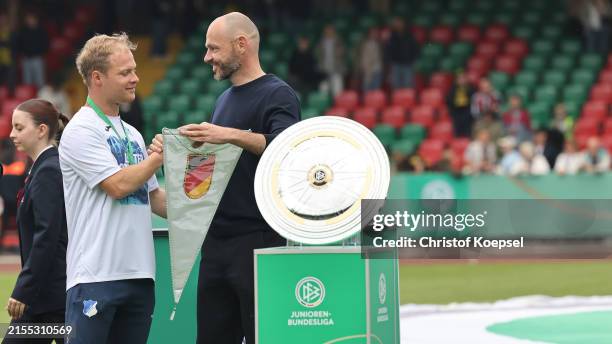 Heiko Wetsermann, head coach of Germany U16 hands out the gold medal to Tobias Nubbemeyer, head coach of Hoffenheim on the podium after the U19...