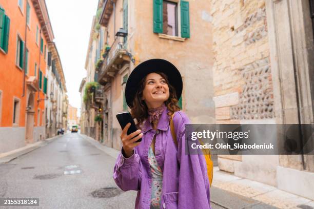 woman using smartphone exploring in verona - purple dress stock pictures, royalty-free photos & images