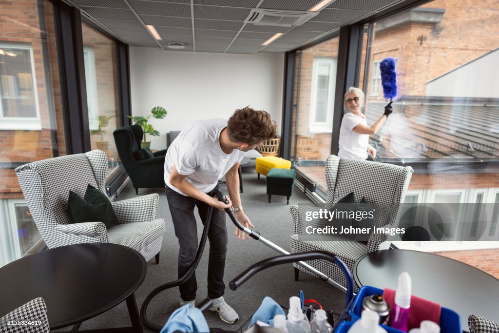 Clean Room Talking Male And Female Janitors Talking While Cleaning Lobby Together High-Res ...