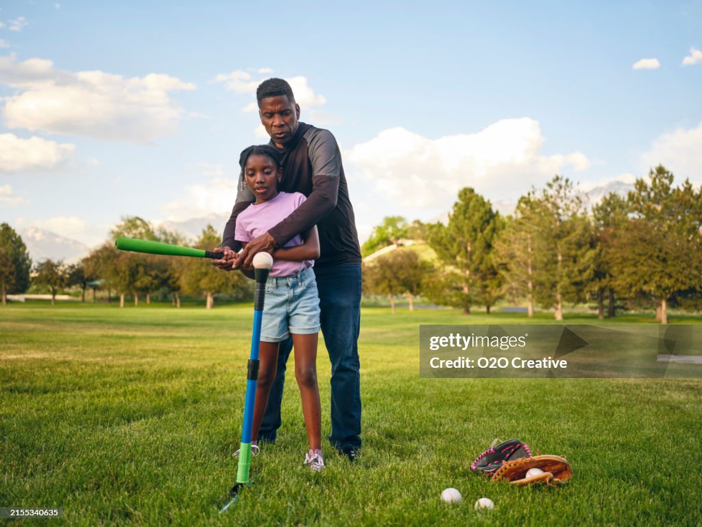 Grandfather and Granddaughter Practicing Baseball in a Park