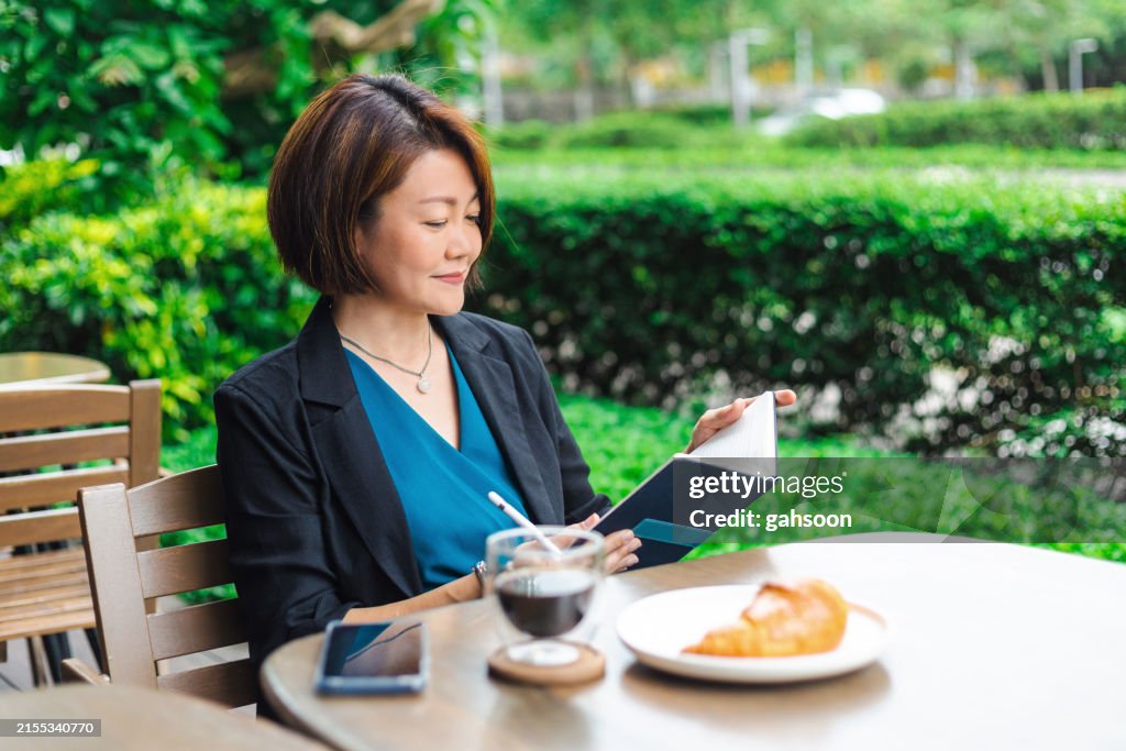 Geschäftsfrau sitzt im Straßencafé