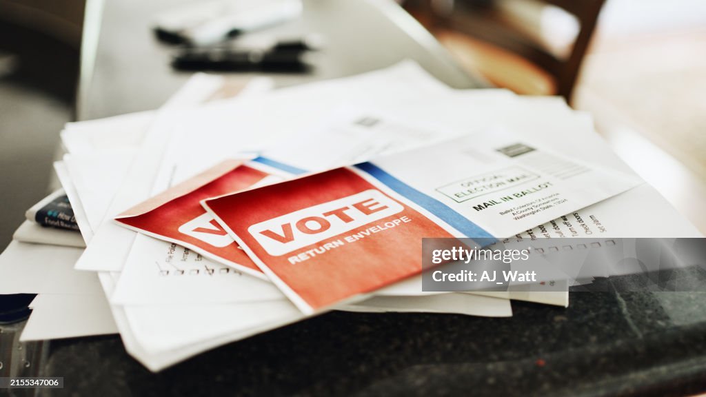 Mail in voting ballots sitting on the kitchen counter of a home