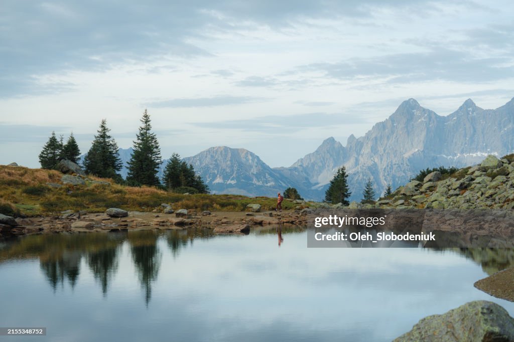 Woman hiking near lake in Alps