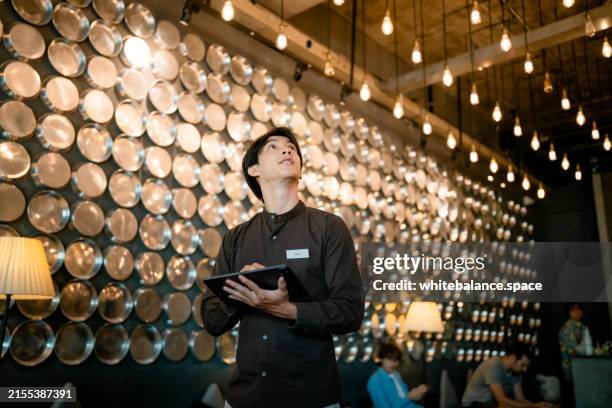 staff adjusting temperature for energy efficiency with a digital tablet. - sustainable business stock pictures, royalty-free photos & images