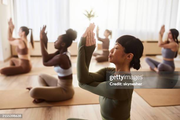 japanese woman exercising yoga on a class in a health club. - posture stock pictures, royalty-free photos & images