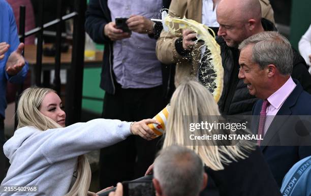 Person throws a milkshake drink in the face of newly appointed leader of Britain's right-wing populist party, Reform UK, and the party's...
