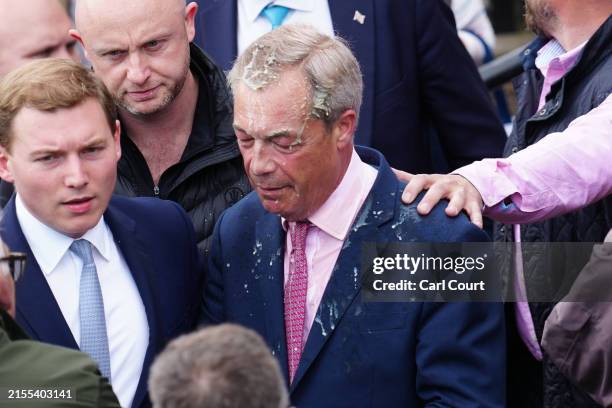 Reform UK party leader Nigel Farage reacts after a woman threw a drink over him, as he launches his election candidacy at Clacton Pier on June 4,...