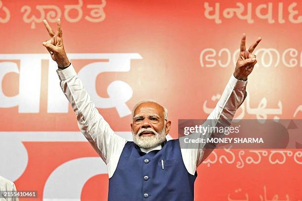 India's Prime Minister Narendra Modi flashes victory sign at the Bharatiya Janata Party headquarters to celebrate the party's win in country's...