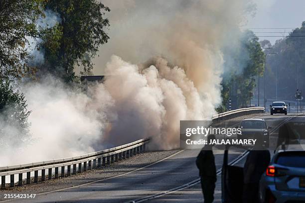 Smokes rises from the woods which caught fire following rockets launched from Lebanon into northern Israel, close to the city of Kiryat Shmona near...