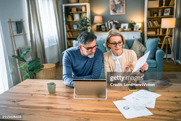 mature couple manages expenses and bills - bank account stock pictures, royalty-free photos & images