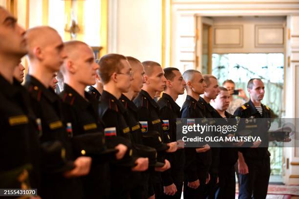 Russian navy recruits pray during a ceremony marking the departure of recruits to join the army, in Saint Petersburg on June 4, 2024.
