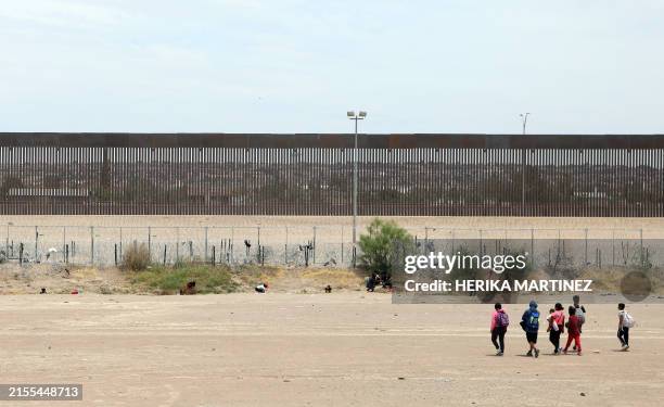 Migrants seeking asylum in the United States remain on the bank of the Rio Grande after crossing from Ciudad Juarez, Chihuahua State, Mexico, on June...
