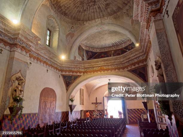 front of san xavier del bac mission church with pilgrims and tourists entering church - southern arizona stock pictures, royalty-free photos & images