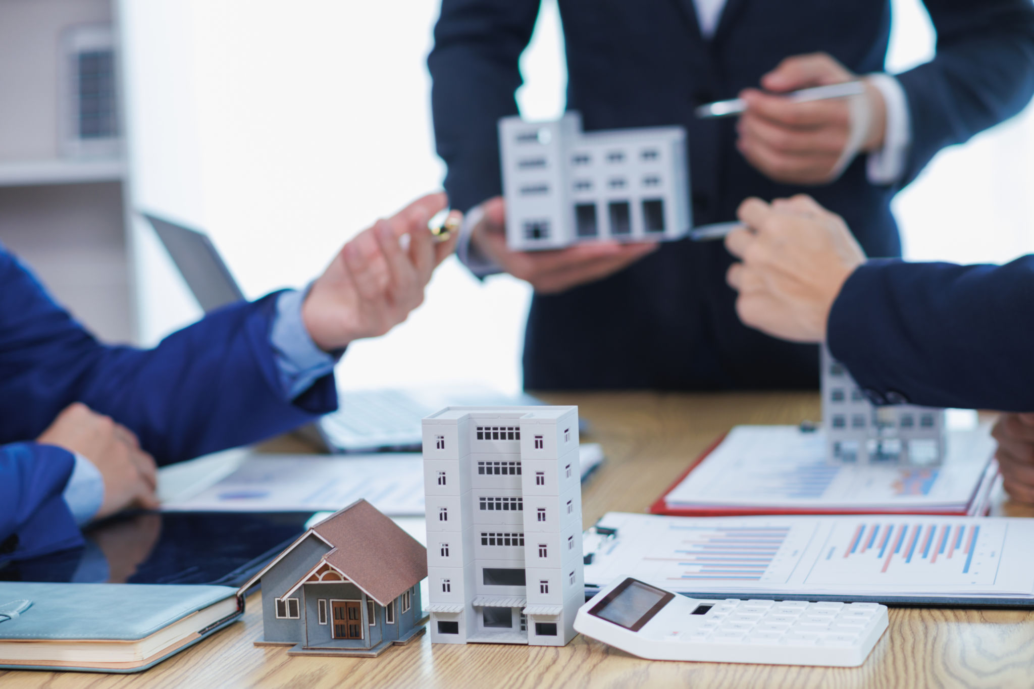 group of businessmen and investors discuss investing in real estate and jointly plan investments in construction projects of condominiums and apartments for sale and rent. investment advisory concept group of businessmen and investors discuss investing in real estate and jointly plan investments in construction projects of condominiums and apartments for sale and rent. investment advisory concept