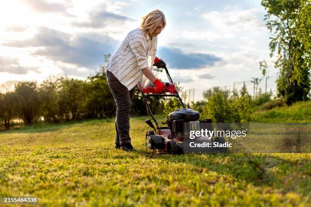 woman working in the garden - gräsklippare bildbanksfoton och bilder