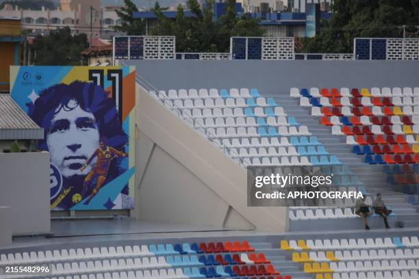 People sitting in stands next to graffiti by former Salvadoran player Jorge "Magico" Gonzalez during the inauguration of the new museum at Jorge...
