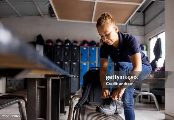 arbeiterin bindet die schnürsenkel an seinen arbeitsstiefeln - arbeitsstiefel stock-fotos und bilder