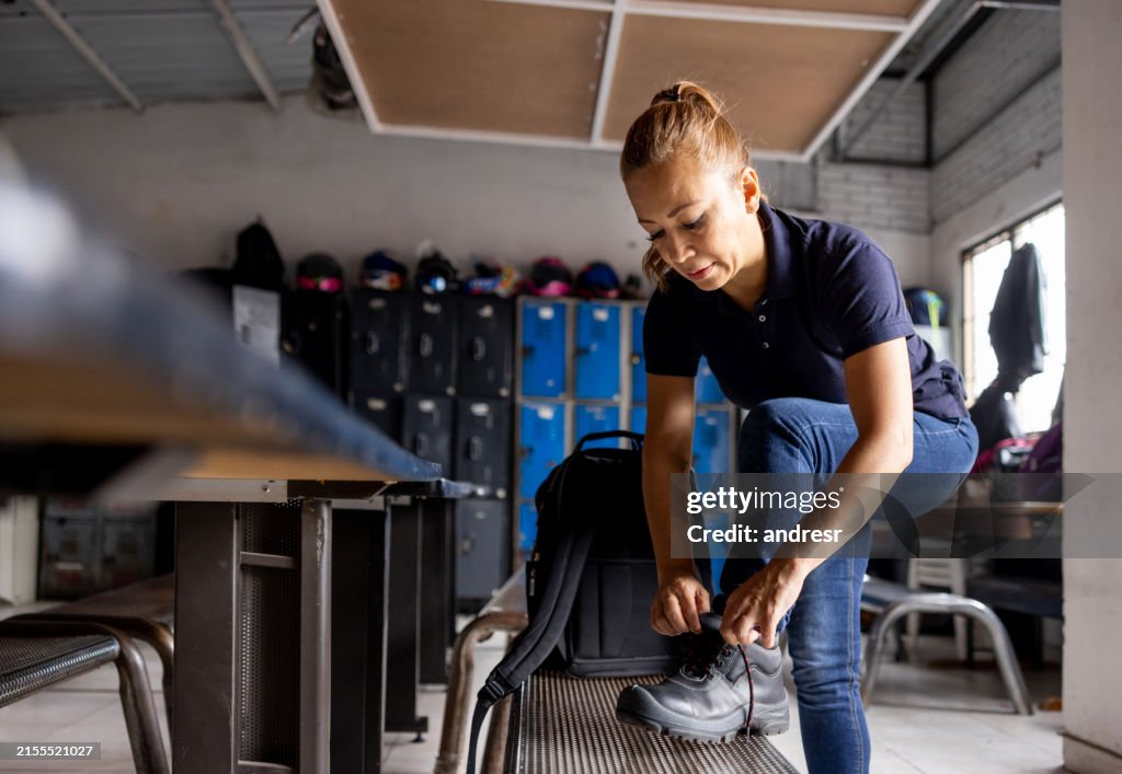 Female worker tying the shoelaces on his work boots