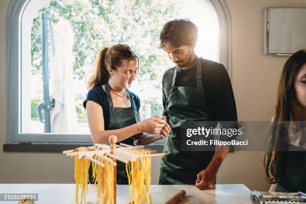 la gente está haciendo ravioles caseros durante una clase de cocina - pasta italiana fotografías e imágenes de stock