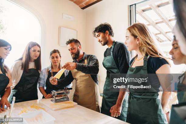 a chef is explaining how to make pasta during a cooking class - italiaanse keuken stockfoto's en -beelden