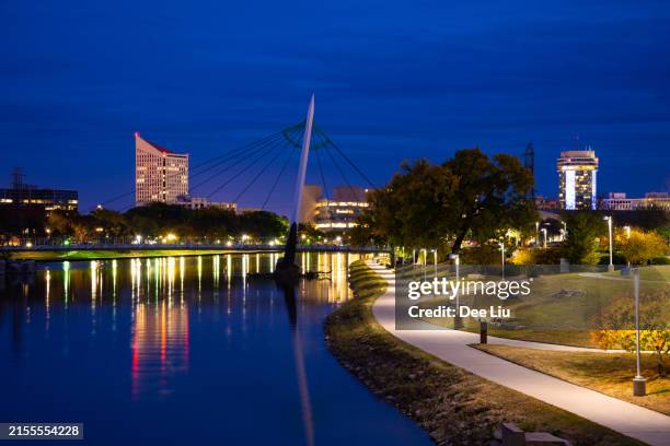 view of wichita's arkansas river pedestrian bridge from river - wichita stockfoto's en -beelden