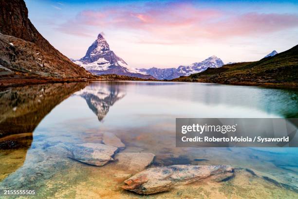 sunrise over matterhorn mirrored in riffelsee lake - lac reflection lake photos et images de collection