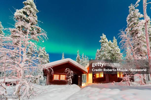 snowy mountain huts under northern ligths - lapónia finlandesa imagens e fotografias de stock