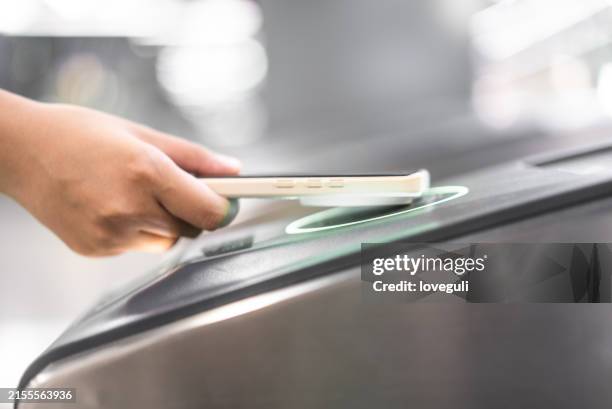 young asian woman using nfc checking in at subway station - train ticket stock pictures, royalty-free photos & images