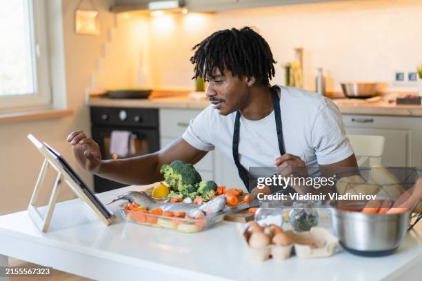 checking a healthy recipe on the internet - cooking class stock pictures, royalty-free photos & images
