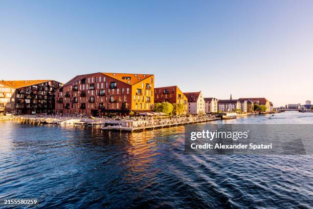 christianshavn waterfront with new apartment buildings and crowd of people relaxing by the river, copenhagen, denmark - christianshavn stock pictures, royalty-free photos & images