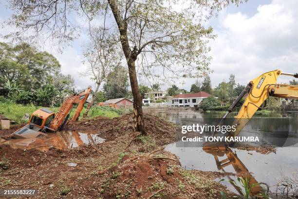 Excavators are marooned in flood water near homes that have been abandoned by their owners at Nairobi's plush Runda estate following recent heavy...