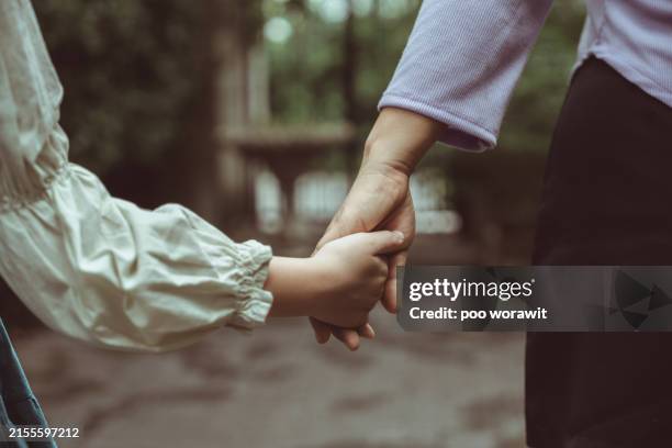 close-up of asian mother and daughter holding hands. - girls holding hands stock pictures, royalty-free photos & images
