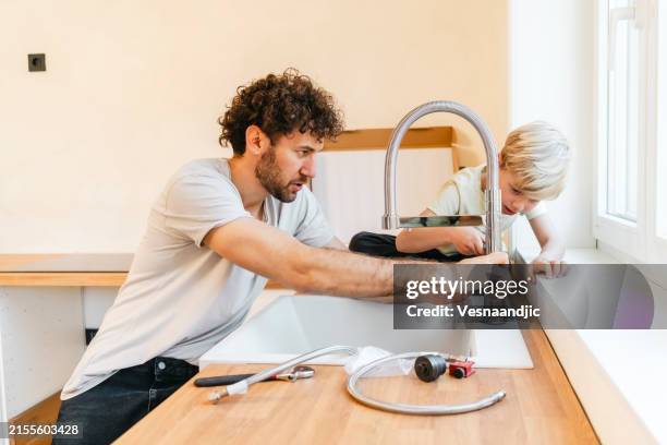 padre e figlio che assemblano mobili da cucina - lavandino foto e immagini stock