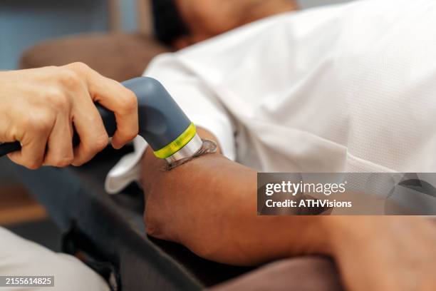 physical therapist using ultrasound therapy on patient arm - tendon stock pictures, royalty-free photos & images