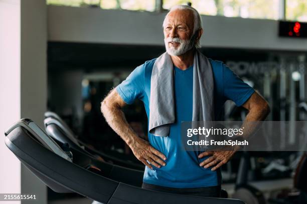 senior man in gym on treadmill with towel around neck - durability stock pictures, royalty-free photos & images