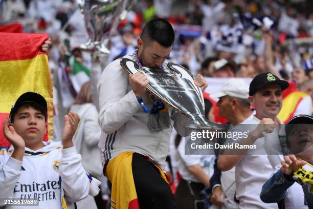 Fan of Real Madrid kisses a cardboard cutout of the UEFA Champions League trophy prior to the UEFA Champions League 2023/24 Final match between...