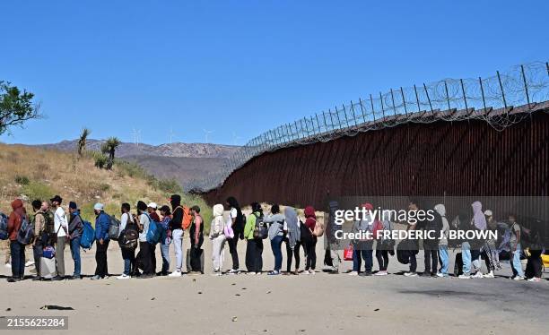 Migrants wait in line hoping for processing from Customs and Border Patrol agents after groups arrived at Jacumba Hot Springs, California, after...
