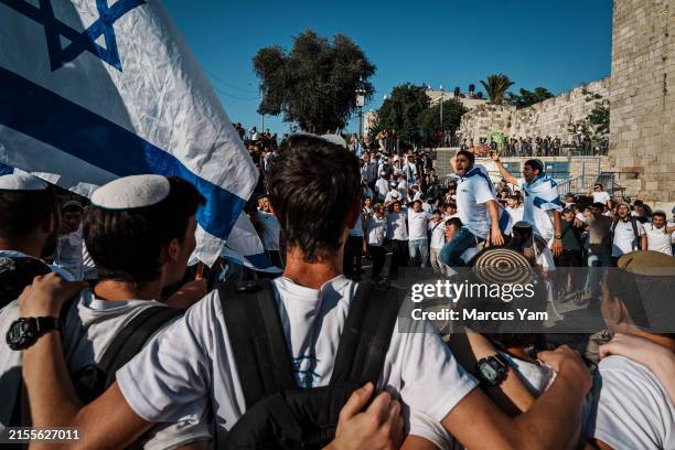 Young religious far right protesters form a circle to sing chants as they take part in the Jerusalem day flag march outside of Damascus Gate and...