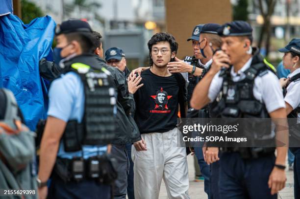 Police escort a man detained for holding a sign. Police were out in full force at the traditional site of a memorial service for those who lost their...