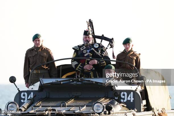 Military piper comes into shore on a DUKW amphibious vehicle ahead of playing a dawn lament on Gold Beach in Arromanches in Normandy, France, to...