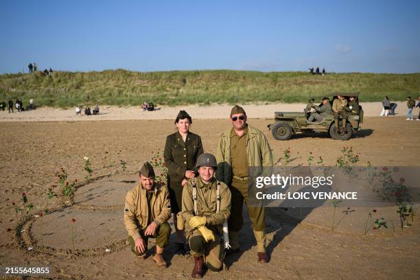 Enthusiasts dressed in replica US Army WWII-era military attire pose for a picture in Utah Beach on June 6, 2024 during the "D-Day" commemorations...