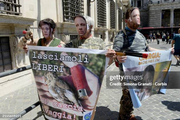 Animal rights activists dressed as hunter s With mask of Giorgia Meloni an Francesco Lollobrigida hold asign saying: Let them be free, protesting in...