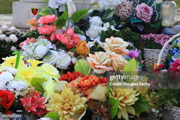 assortment of flowers at an memorial for someone killed - leichenbestatter stock-fotos und bilder