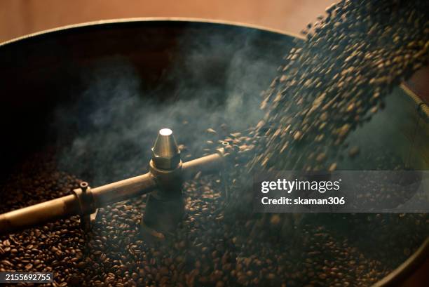 detailed view of coffee beans being roasted in a commercial roasting machine, showcasing the industrial coffee production process. - coffee roaster stock pictures, royalty-free photos & images