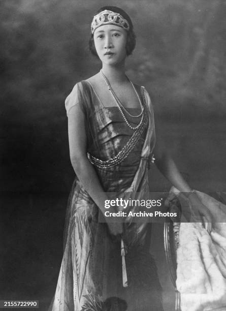 Chinese-Indonesian socialite Madame Wellington Koo, wearing a cap-sleeve dress with pearl necklaces and a tiara, in a studio portrait, taken at the...