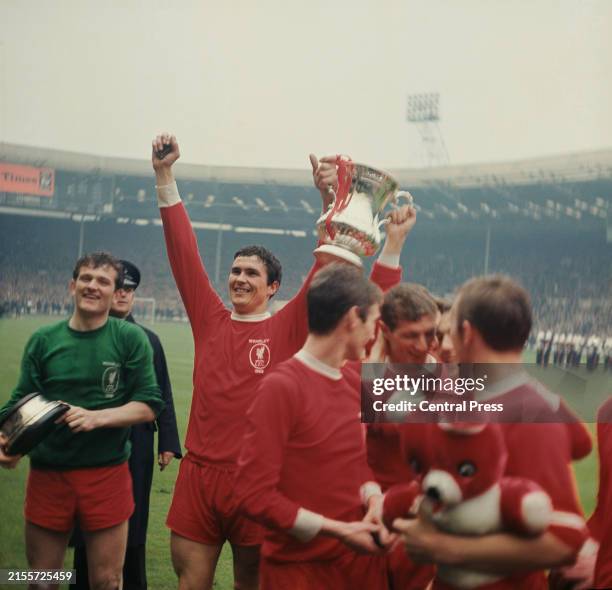 British goalkeeper Tommy Lawrence holds the base of the trophy as his teammate, British footballer Ron Yeats celebrates with the FA Cup trophy...