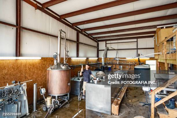 mid adult male whisky distiller working at distillery - distillation stock pictures, royalty-free photos & images