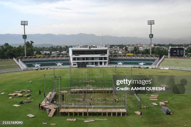 Workers setup a platform before installing big screens at the Rawalpindi Cricket Stadium in Rawalpindi on June 7 for the live telecast of the...